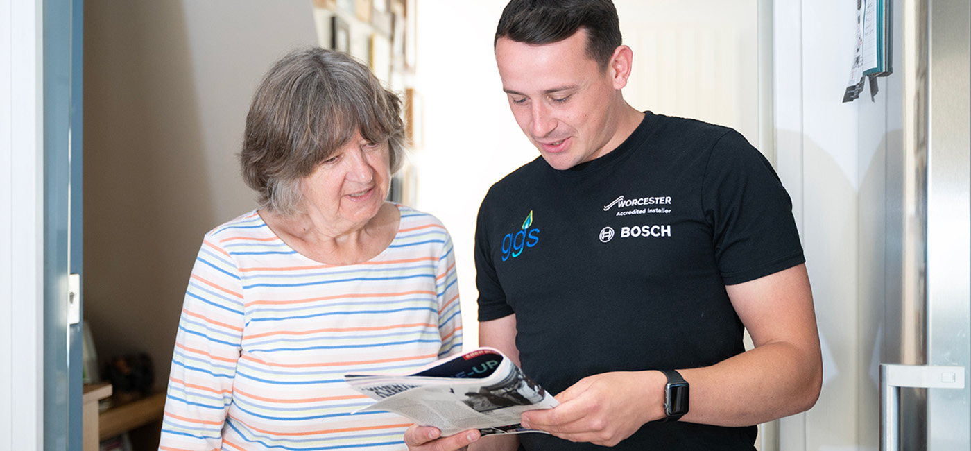 Domestic gas engineer speaking with customer at home